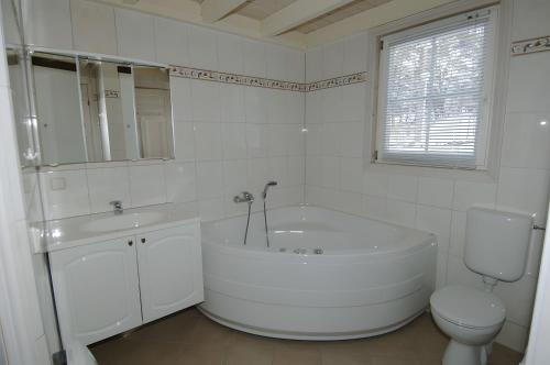 a white bathroom with a tub and a toilet at Ferienhaus Seebär in Baabe