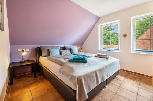 a bedroom with a bed and two windows at Haus Wacholder in Undeloh
