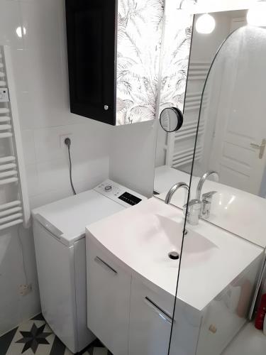 a white bathroom with a sink and a mirror at Maison La Vendéenne - Ref 508 in La Tranche-sur-Mer