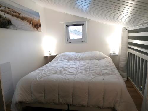 a bedroom with a white bed and a window at Maison La Vendéenne - Ref 508 in La Tranche-sur-Mer