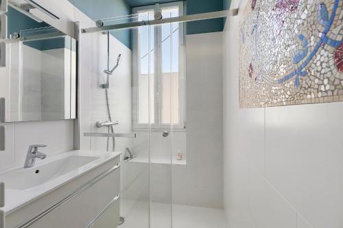 a white bathroom with a sink and a shower at Quartier De La Madeleine in Angers