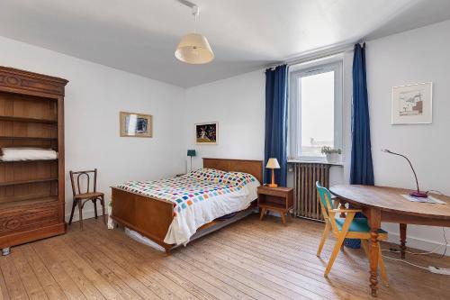 a bedroom with a bed and a desk and a table at Quartier De La Madeleine in Angers