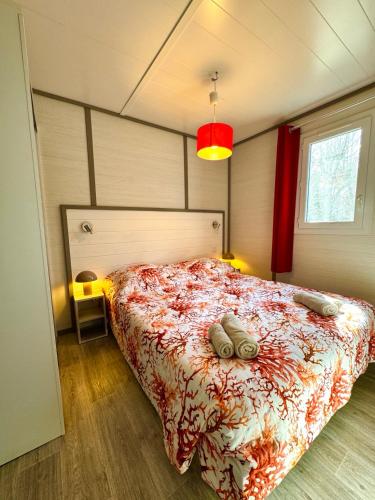 a bedroom with a bed with a red comforter at Campo Vecchio Mare et Piscine in Ghisonaccia