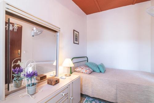 a bedroom with a bed and a large mirror at Casa das Bonecas in Farelos de Baixo