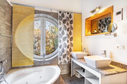 a bathroom with two sinks and a large window at Sonnenuferhaus in Kosel