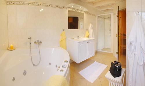 a white bathroom with a tub and a sink at Ferienhaus 254 Strandpark Baabe in Baabe