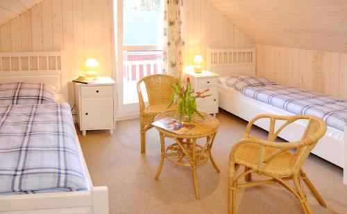 a bedroom with two beds and a table and chairs at Ferienhaus 254 Strandpark Baabe in Baabe