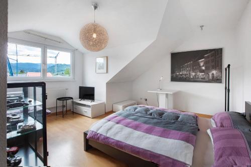 a bedroom with a bed and a tv on the wall at Haus Castellbergblick Dachgeschoss in Ballrechten