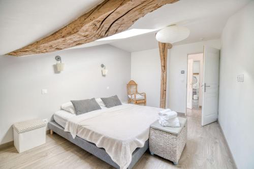 a white bedroom with a large bed and a wooden ceiling at Villa Virginie gite 1 in Faudoas