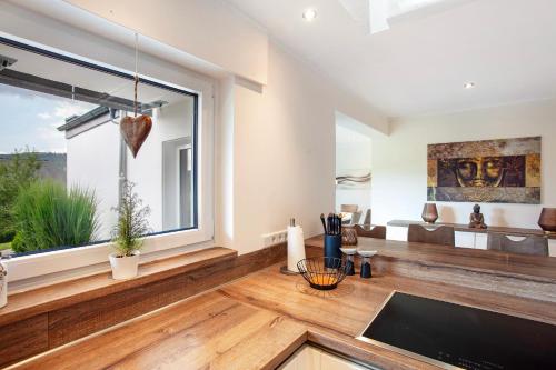 a living room with a large window and wooden floors at Ferienwohnung Am Wald in Eslohe