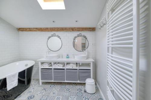 a bathroom with a tub and a sink and mirror at Villa Virginie gite 1 in Faudoas