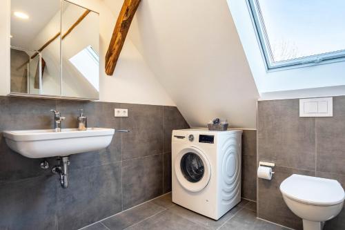 a bathroom with a washing machine and a sink at Pendler- und Ferienwohnung Bröke in Ahaus