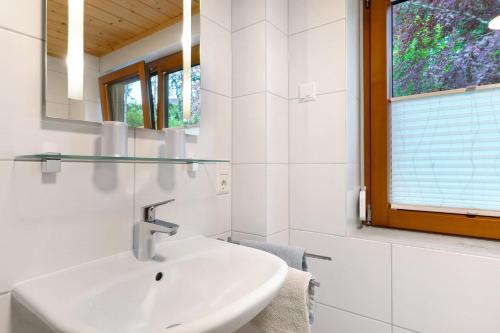 a white bathroom with a sink and a window at Sulzerhof in Bad Rippoldsau-Schapbach