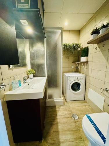 a bathroom with a sink and a washing machine at Casa Azul Torreira in Torreira