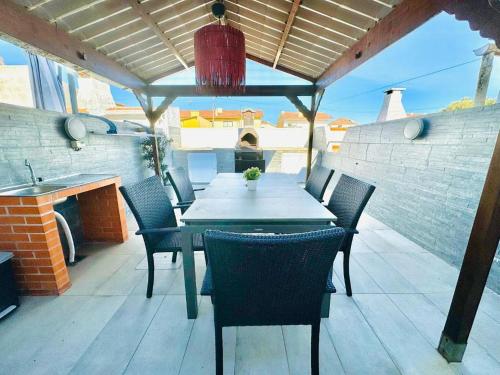 a dining table and chairs on a patio at Casa Azul Torreira in Torreira