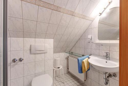 a white bathroom with a sink and a toilet at Appartment Bergblick in Bernau im Schwarzwald