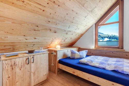 a bedroom with a bed and a window in a cabin at Appartment Bergblick in Bernau im Schwarzwald