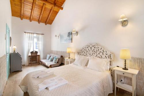 a bedroom with a large white bed and a living room at Quinta do Mestre - Casa Do Mar in Tavira