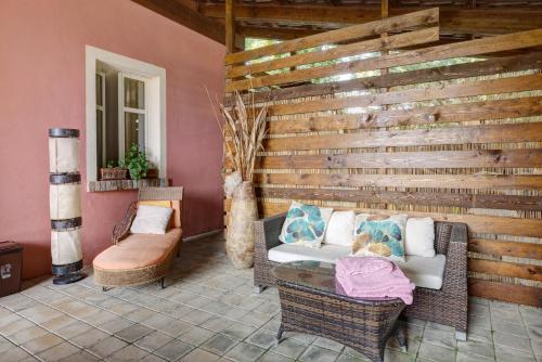 a patio with chairs and a wooden wall at Cascina Manzo in Dogliani
