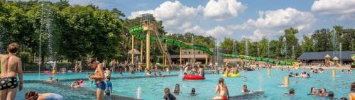 a group of people in a pool at a water park at Luxe chalet voor gezinnen in familiepark Goolderheide met openlucht zwembaden en ruim overdekt terras 24m2 in Bocholt