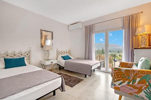 a hotel room with two beds and a balcony at Ayora in Jávea