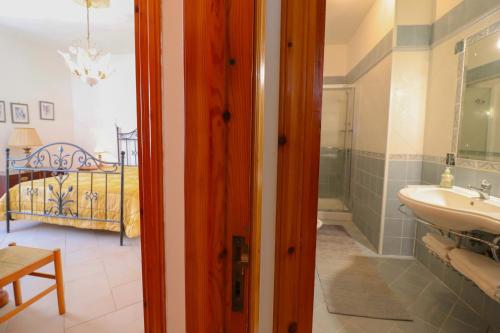 a bathroom with a sink and a bedroom with a bed at Casa Kefera a Otranto in Otranto