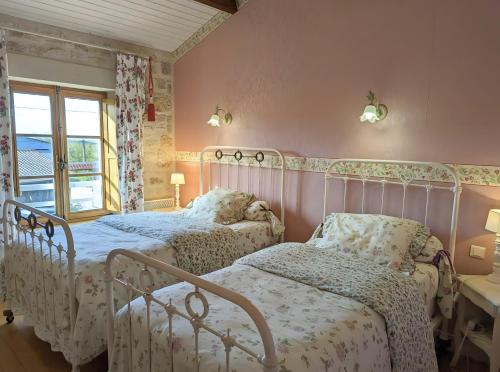 two beds in a bedroom with pink walls at Le Clos Pierreslogis in Theil-Rabier