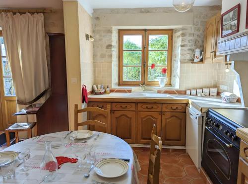 a kitchen with a table and a sink at Le Clos Pierreslogis in Theil-Rabier