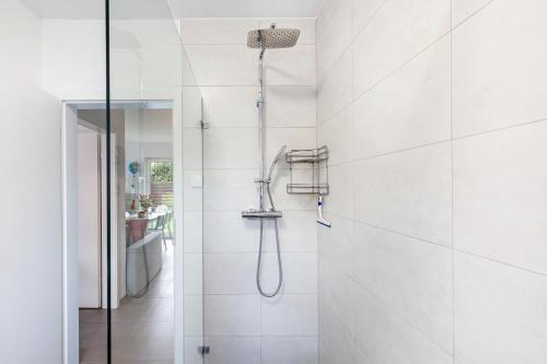 a shower in a bathroom with white tiles at Ferien Marx in Oberbrechen