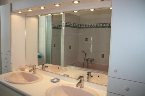 a bathroom with two sinks and a large mirror at Le Mas des Cigales in Avignon