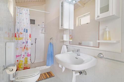 a bathroom with a sink and a toilet and a mirror at The Sea Martin in Nydri