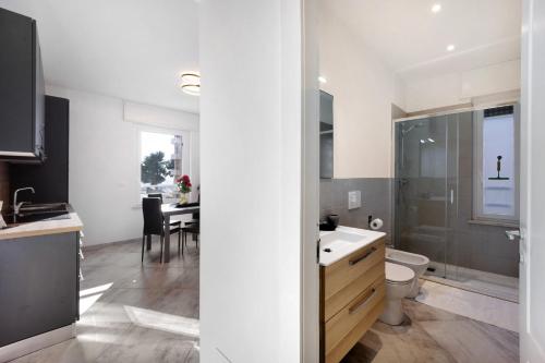 a bathroom with a sink and a toilet and a table at Casa Daniele Vista Mare - Sanremo in Sanremo