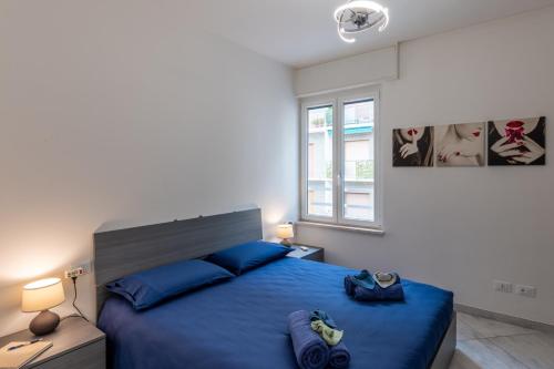 a bedroom with a large blue bed with blue pillows at Casa Daniele Vista Mare - Sanremo in Sanremo