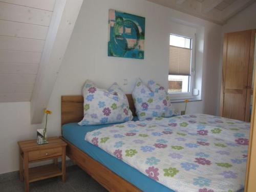 a bedroom with a bed with blue sheets and pillows at Apfelhof - Ferienwohnung Wielath in Salem