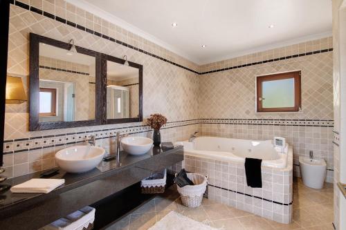a bathroom with two sinks and a tub and two toilets at Quinta dos Fontanais in Tavira