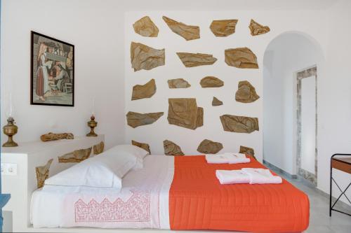 a bedroom with a bed and rocks on the wall at Politimis Studio N4 in Amorgos