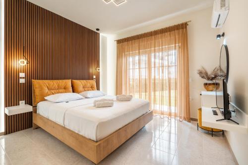 a bedroom with a large bed and a television at Eldorado Luxury Villa in Afantou