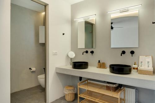 a bathroom with a sink and a mirror at Blueros - Black Stone Suite in Megas Gialos - Nites