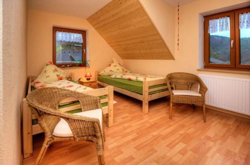 a small room with a bed and two chairs at Dischhansenhof in Glottertal