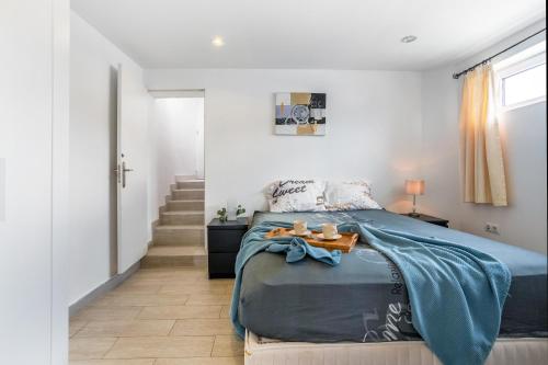 a bedroom with a bed with a blue blanket at Beach House el Poris 2 in Poris de Abona
