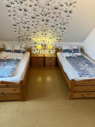 two twin beds in a room with two lamps at Ferienwohnung Utkiek in Ihlow