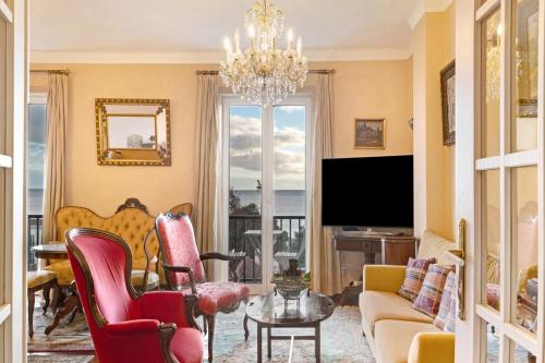a living room with a chandelier and a tv at Bela Sao Tiago 36 in Funchal