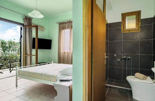 a bedroom with a bed and a bathroom with a shower at Old Boat double studio 5 in Nikiana