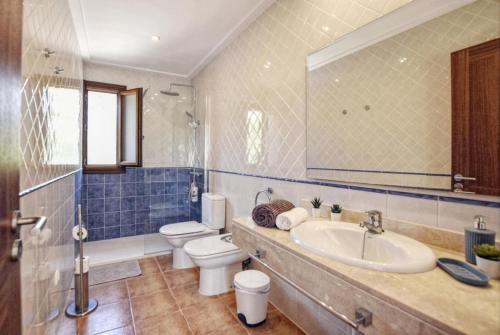 a bathroom with a sink and a toilet and a mirror at Ines in Inca