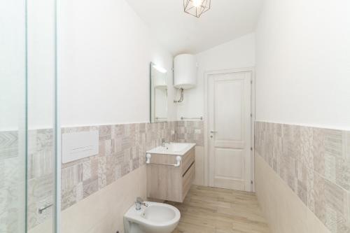 a bathroom with a toilet and a sink and a mirror at Casa Virgi vista mare in Budoni