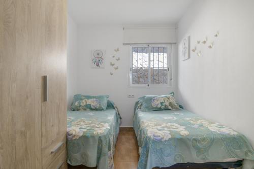 a bedroom with two beds and a window at Casa Rocio in Barrio Nuevo