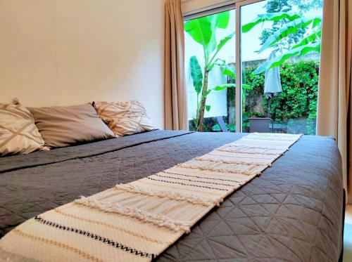 a bed in a bedroom with a large window at Casa Maya Villa with Private Pool Bar and Parking Merida in Mérida