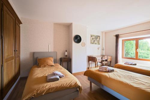 a bedroom with two beds and a window at Gite Cours Péan in Châteaugiron