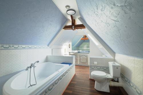 a bathroom with a white tub and a toilet at Gite Cours Péan in Châteaugiron