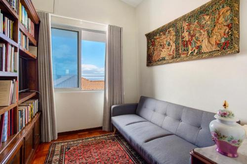 a living room with a couch and a large window at Casa Caminho do Palheiro - Funchal in Funchal